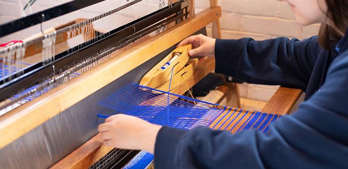 close up of a BSU student weaving on a loom